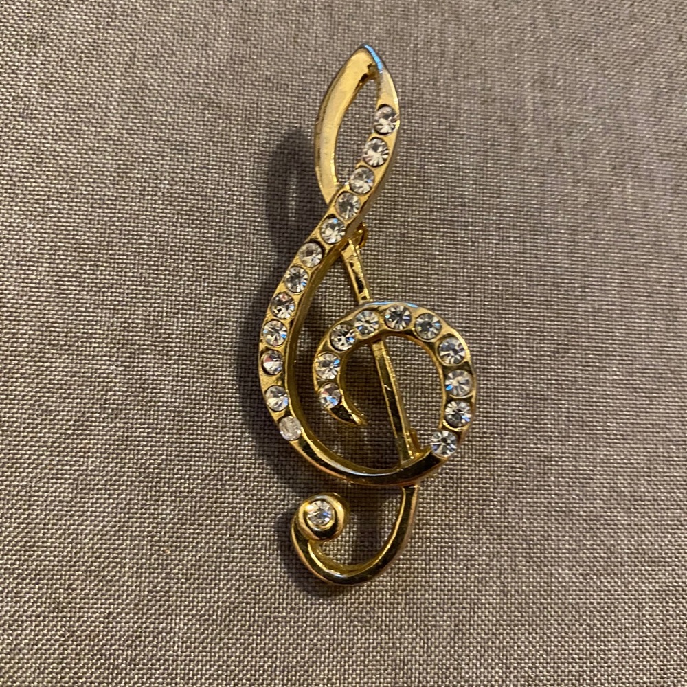 Vintage brass pin, treble clef music note